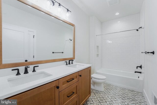 full bathroom featuring tiled shower / bath combo, vanity, and toilet