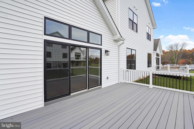 wooden deck featuring a lawn