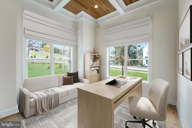 office space with coffered ceiling, ornamental molding, beam ceiling, and light hardwood / wood-style floors