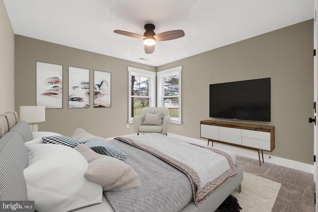 carpeted bedroom with baseboards, visible vents, and a ceiling fan