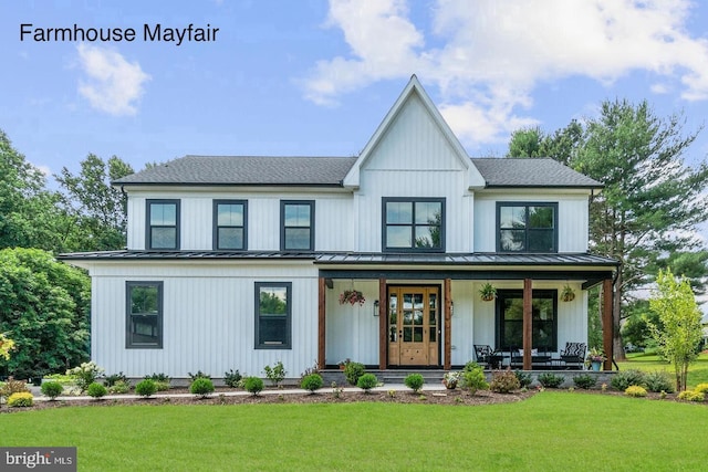 modern farmhouse featuring covered porch, a standing seam roof, metal roof, and a front yard