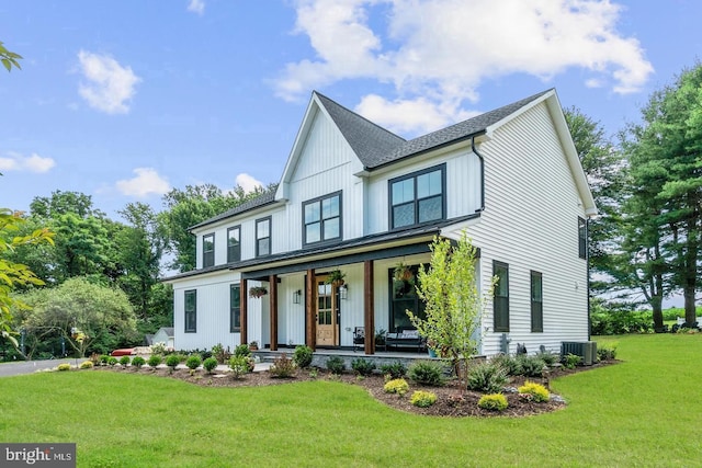 view of front facade with cooling unit, a front lawn, and covered porch