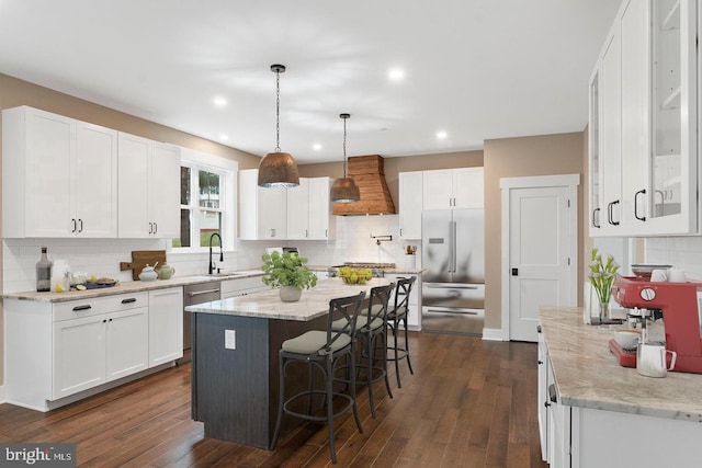 kitchen featuring custom exhaust hood, appliances with stainless steel finishes, dark hardwood / wood-style floors, and white cabinetry