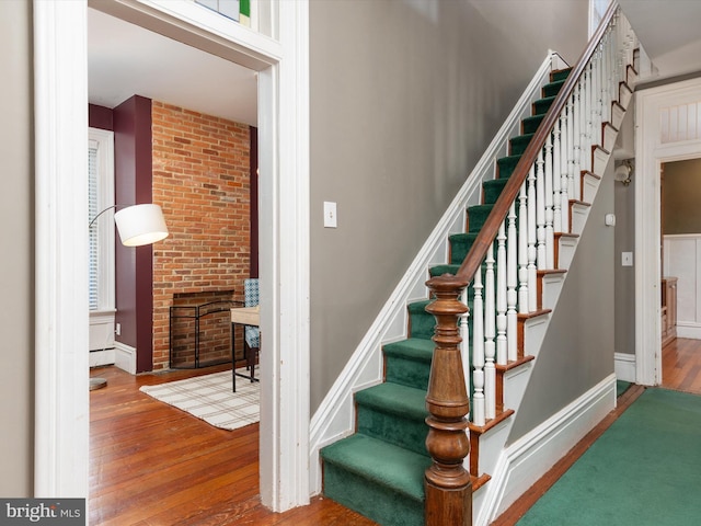 staircase featuring a fireplace and hardwood / wood-style flooring