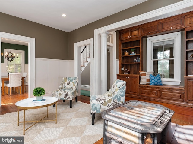 sitting room with built in shelves, light hardwood / wood-style flooring, and a notable chandelier