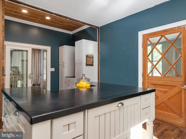 kitchen with white cabinets, hardwood / wood-style floors, and ornamental molding