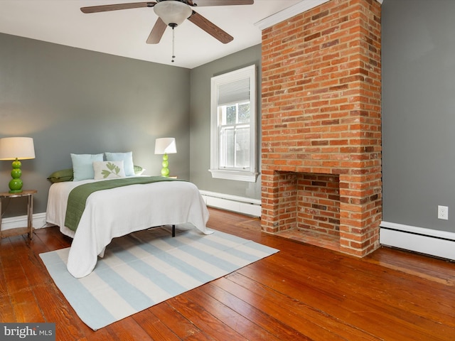 bedroom with hardwood / wood-style floors, ceiling fan, and baseboard heating