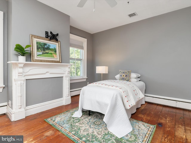 bedroom featuring ceiling fan, dark hardwood / wood-style flooring, and a baseboard radiator