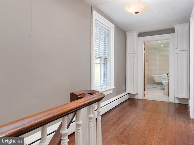 hallway featuring a baseboard radiator and dark wood-type flooring