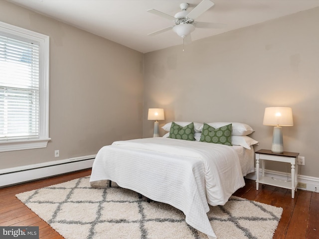 bedroom featuring dark hardwood / wood-style floors, ceiling fan, and a baseboard heating unit