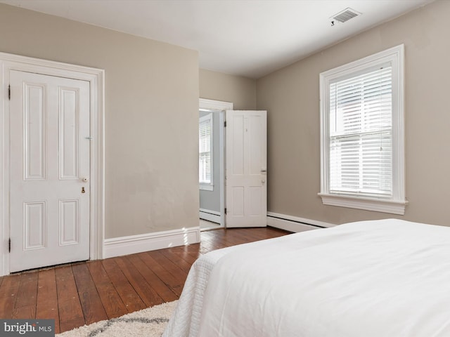 bedroom featuring dark hardwood / wood-style floors, a baseboard radiator, and multiple windows