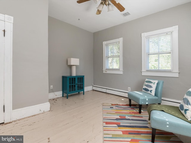 sitting room with ceiling fan, light hardwood / wood-style floors, and a baseboard heating unit