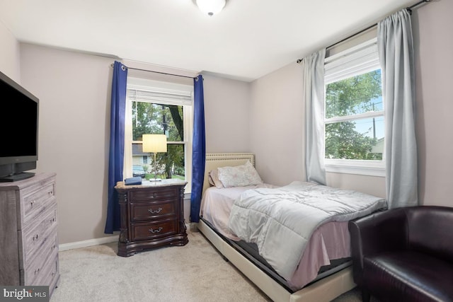 bedroom with multiple windows and light colored carpet