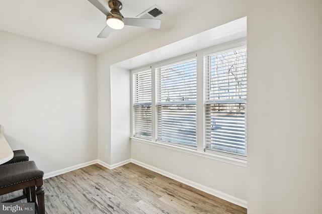 unfurnished room featuring ceiling fan, wood finished floors, visible vents, and baseboards