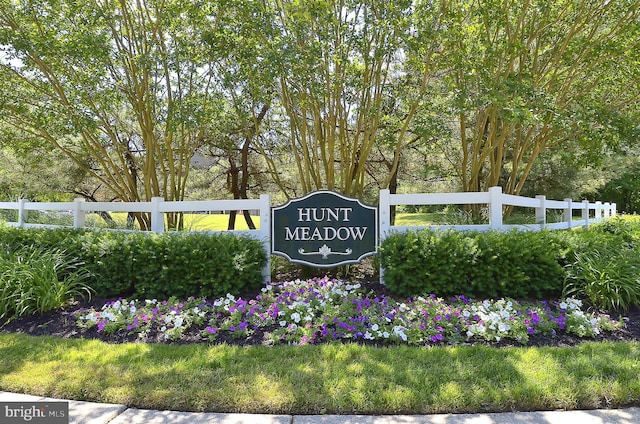 community / neighborhood sign featuring fence