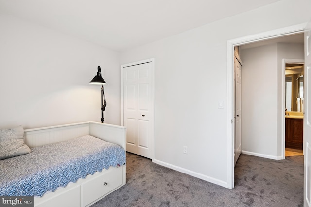 carpeted bedroom with a closet and baseboards