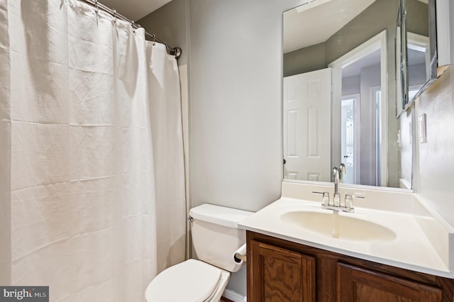 full bathroom featuring vanity, a shower with shower curtain, and toilet