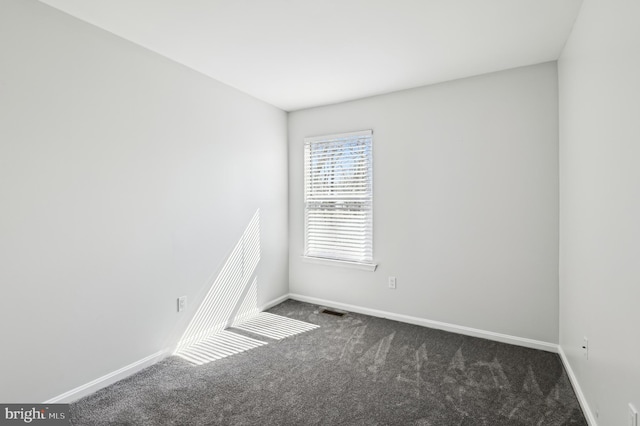 carpeted empty room featuring visible vents and baseboards