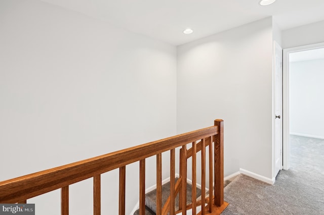 hall featuring an upstairs landing, carpet flooring, recessed lighting, and baseboards