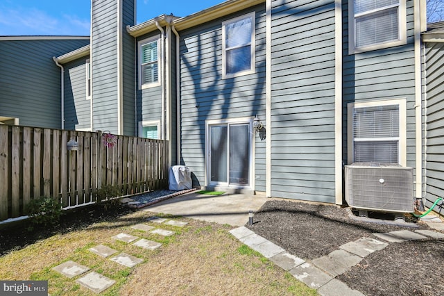 rear view of property with a patio, central air condition unit, fence, and a chimney