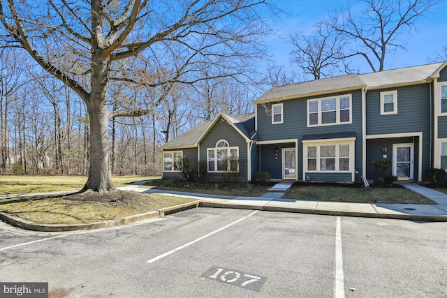 townhome / multi-family property with a shingled roof and uncovered parking