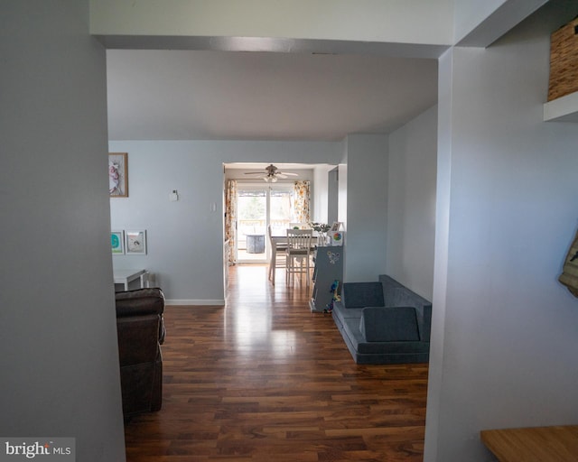 corridor featuring baseboards and wood finished floors