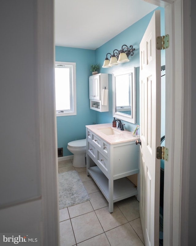 half bathroom with toilet, tile patterned flooring, and vanity