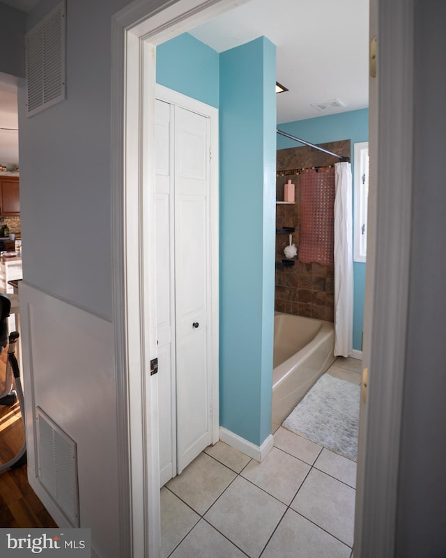 full bathroom with a closet, tile patterned flooring, visible vents, and shower / bathtub combination with curtain