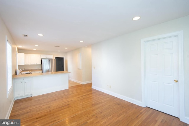 unfurnished living room with light wood-type flooring and sink