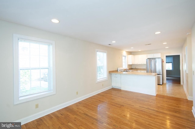 unfurnished living room featuring light hardwood / wood-style floors and sink