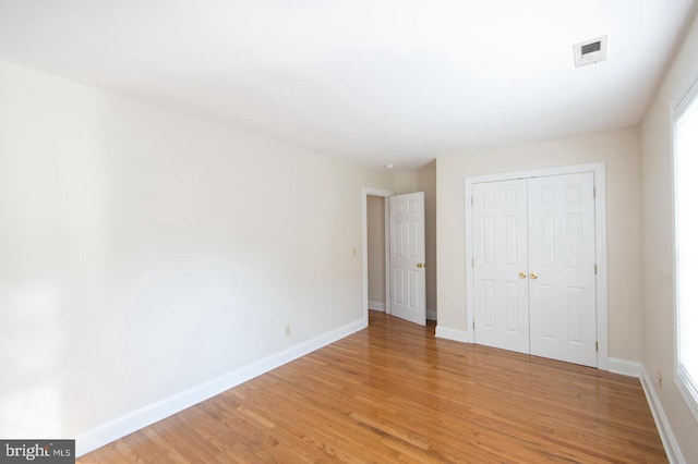 unfurnished bedroom featuring light hardwood / wood-style flooring and a closet