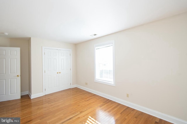 unfurnished bedroom featuring a closet and hardwood / wood-style floors