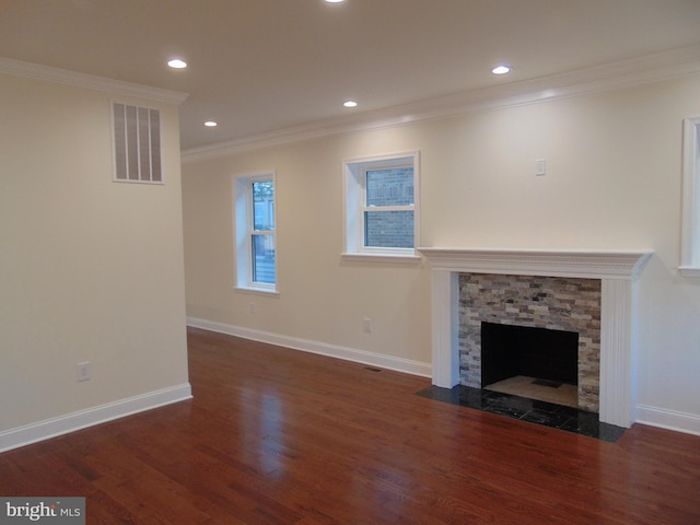 unfurnished living room featuring ornamental molding, dark wood-type flooring, and a stone fireplace