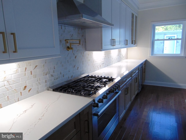 kitchen with dark hardwood / wood-style floors, wall chimney range hood, crown molding, light stone countertops, and stainless steel range