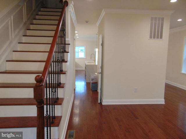 stairs featuring wood-type flooring and ornamental molding