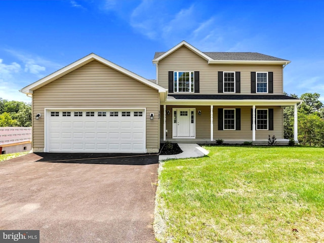 view of property with a garage, a front lawn, and covered porch