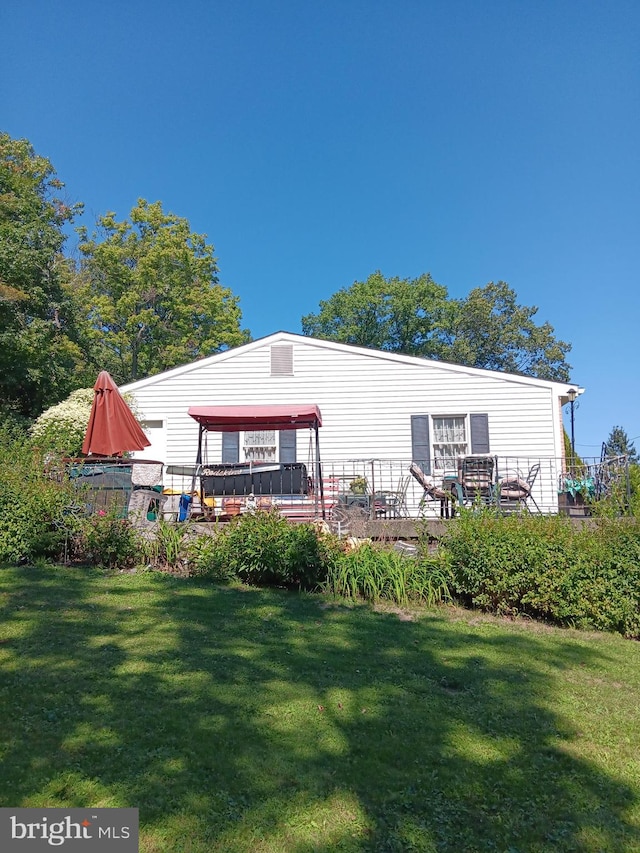 rear view of house featuring a lawn, a gazebo, and a deck