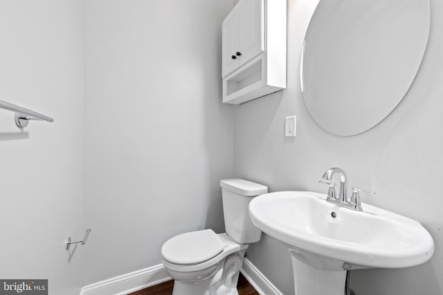 bathroom featuring sink, hardwood / wood-style floors, and toilet