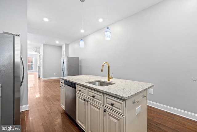 kitchen featuring an island with sink, appliances with stainless steel finishes, hanging light fixtures, and sink