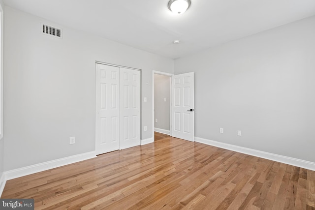 unfurnished bedroom featuring a closet and hardwood / wood-style flooring