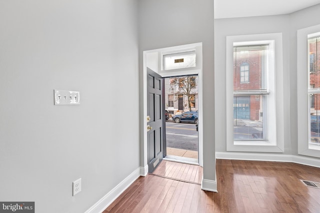 foyer entrance with hardwood / wood-style flooring and a healthy amount of sunlight