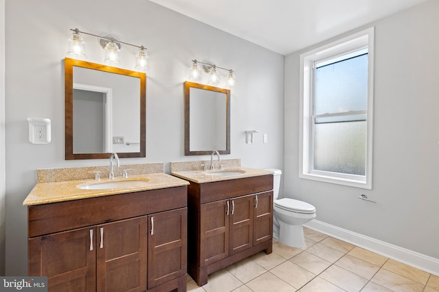 bathroom with vanity, plenty of natural light, toilet, and tile patterned floors