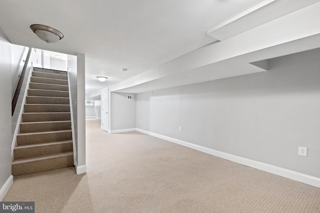 basement featuring light carpet