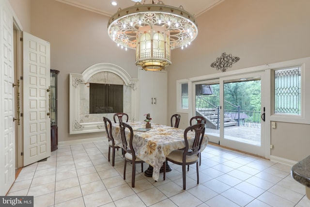 dining space featuring an inviting chandelier, a high ceiling, light tile patterned floors, and crown molding