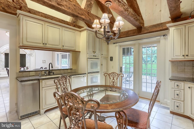 interior space with light tile patterned floors, a notable chandelier, sink, and beam ceiling