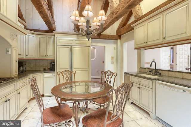 tiled dining space with sink, lofted ceiling with beams, and a chandelier