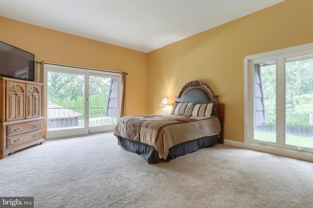 bedroom with access to outside, carpet floors, and multiple windows