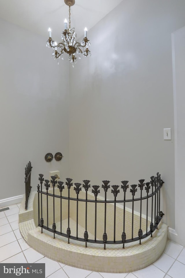 stairs with a chandelier and tile patterned floors