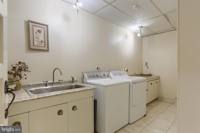 washroom with cabinets, light tile patterned floors, washer and dryer, and sink