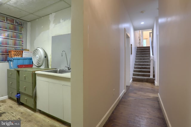 corridor with light wood-type flooring and sink